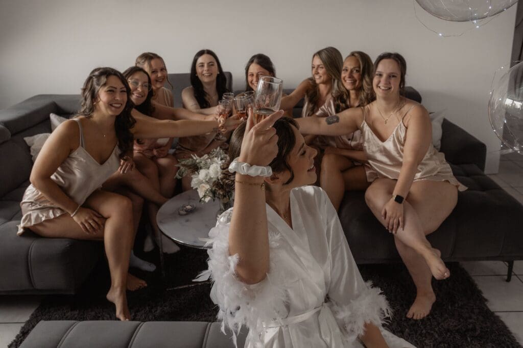Braut stößt mit Brautjungfern beim Getting Ready für die Hochzeit in Aachen an
