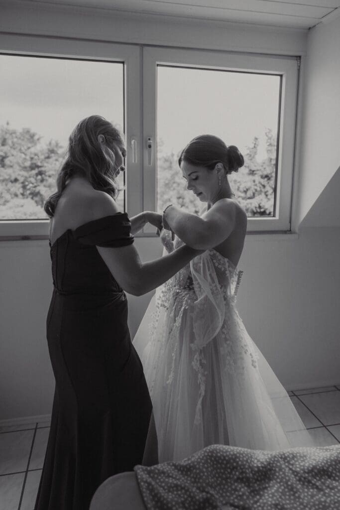 Die Brautmutter hilft ihrer Tochter beim anziehen des Hochzeitskleids beim Getting Ready in Aachen
